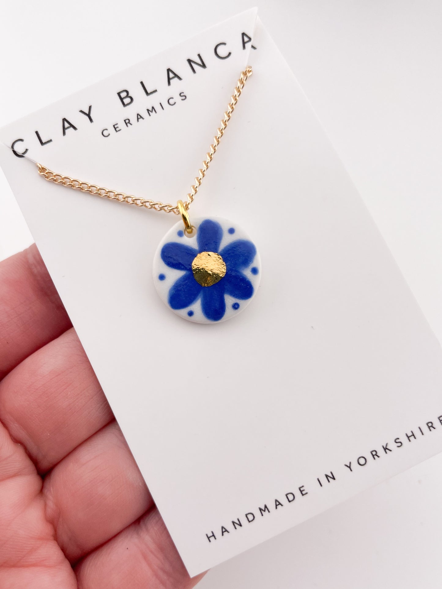 Hand painted blue flower pendant with gold centre