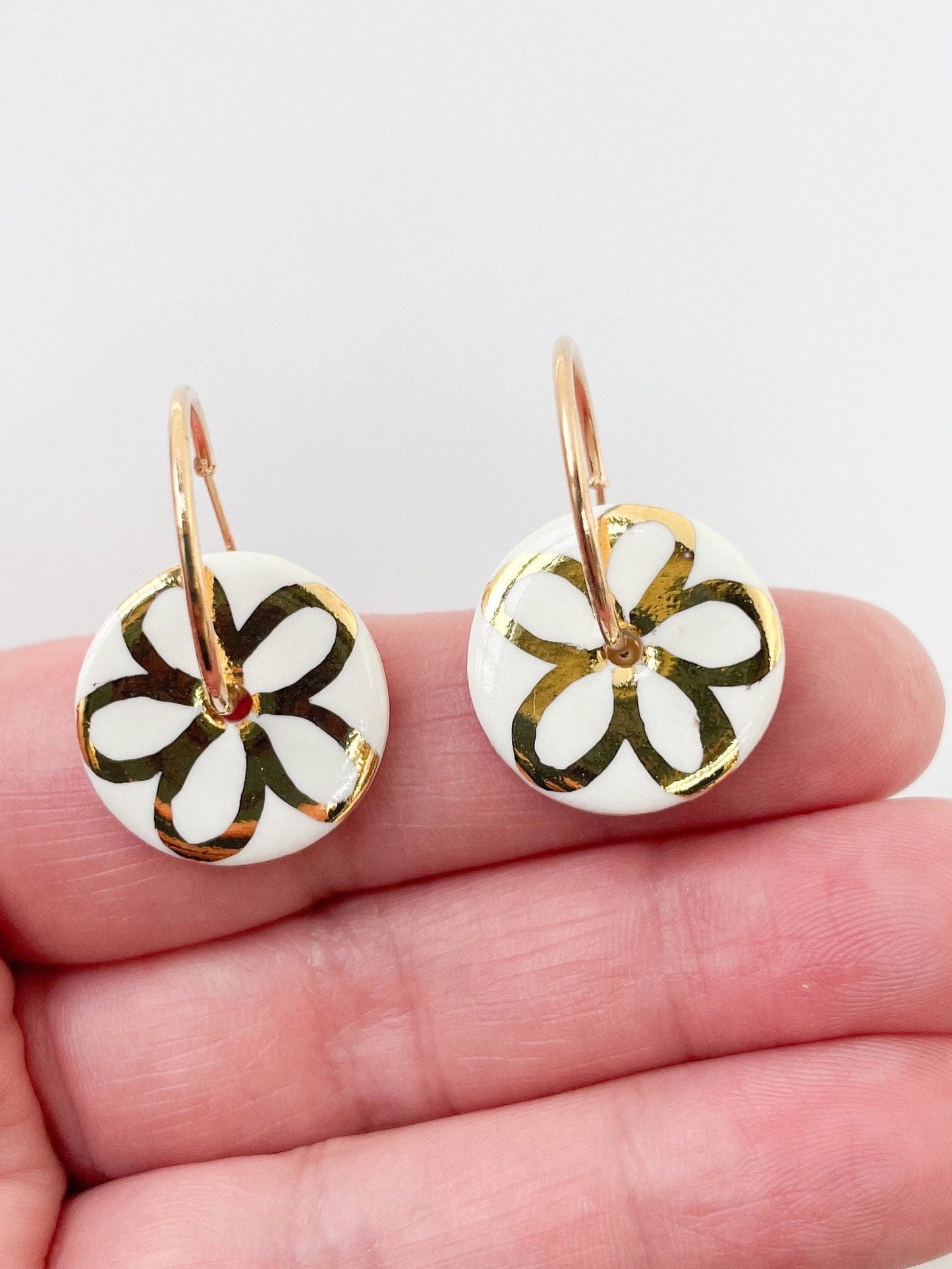 White round earring with gold flower