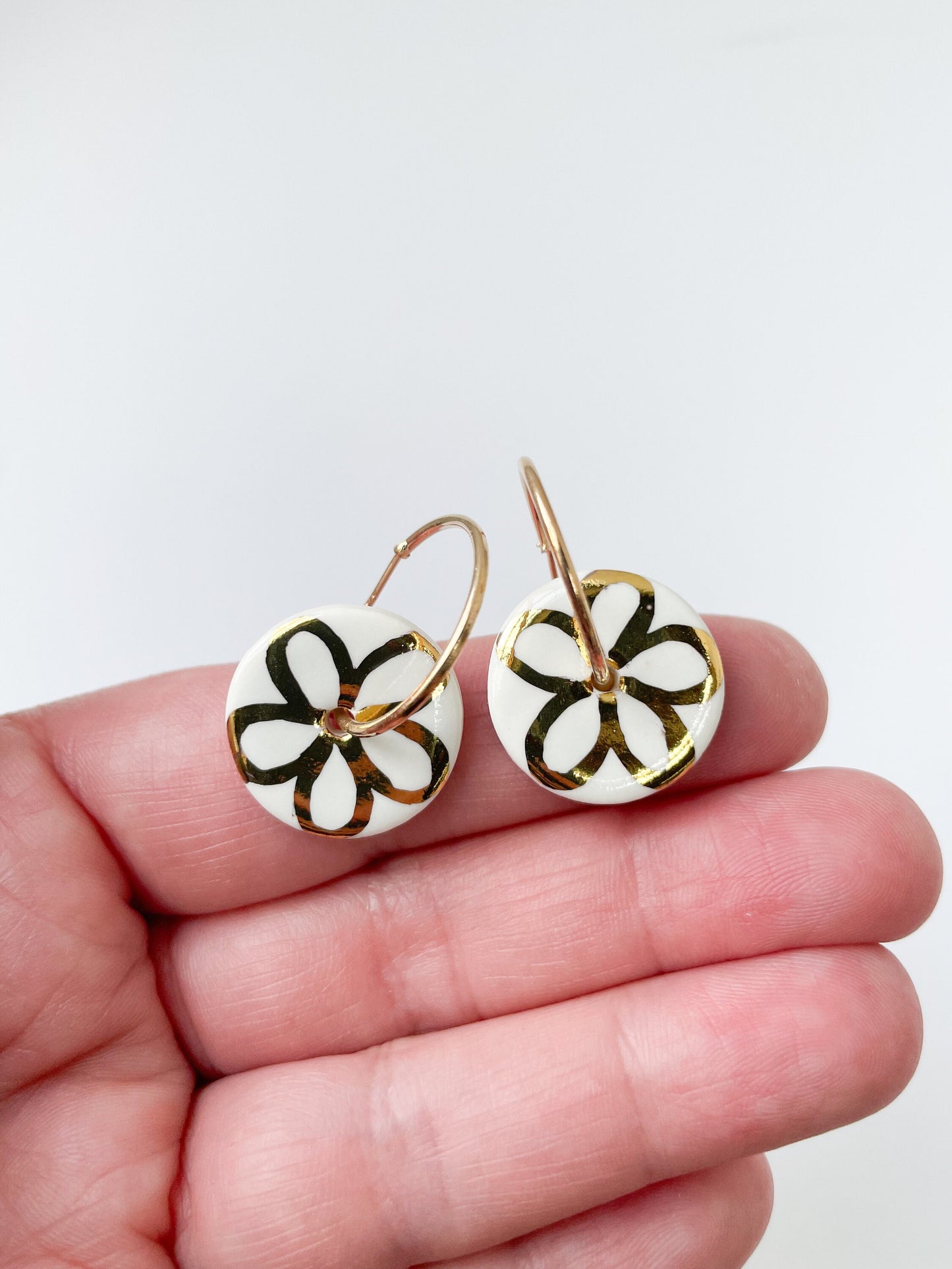 White round earring with gold flower