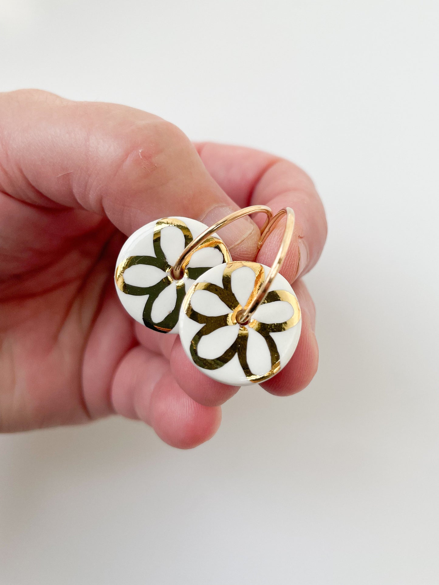 White round earring with gold flower